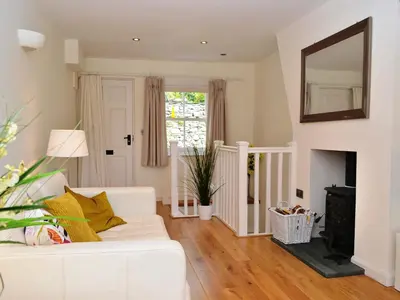 a living room with a white couch and a mirror at 5 The Plosh in Keswick