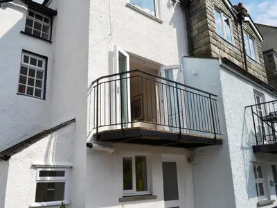 a white building with a balcony on the side of it at 5 The Plosh in Keswick