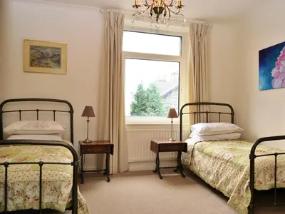 a bedroom with two beds and a window at Catbells Cottage Keswick in Keswick