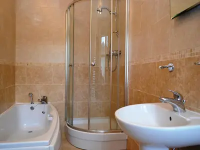 a bathroom with a shower and a sink and a tub at Catbells Cottage Keswick in Keswick