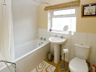 a bathroom with a sink and a tub and a toilet at Bridge Cottage in Braithwaite