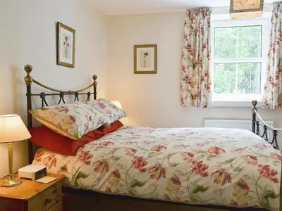 a bedroom with a bed and a window at Joan's Cottage in Braithwaite