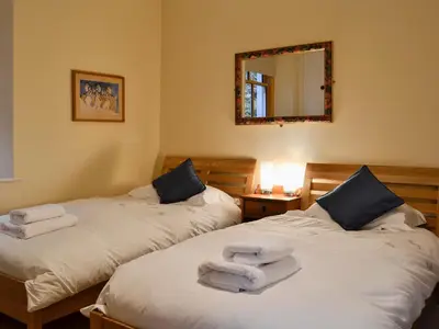 two beds in a room with towels on them at The Larches in Braithwaite