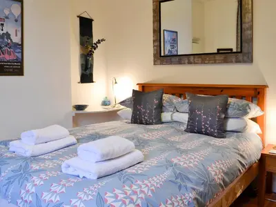 a bedroom with a bed with towels on it at The Larches in Braithwaite