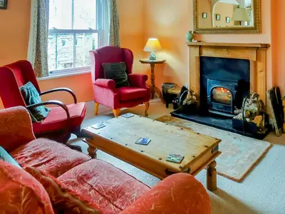 a living room with a couch and a fireplace at Thwaite Hill Cottage in Braithwaite