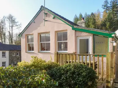 a house with a wooden fence in front of it at Thwaite Hill Cottage in Braithwaite