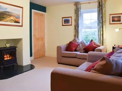 a living room with two couches and a fireplace at Beech End in Braithwaite