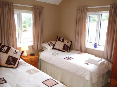 two beds in a small room with windows at Beech End in Braithwaite