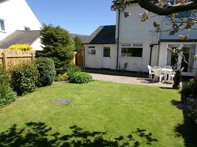 a garden with a table and chairs in a yard at Roseworth in Portinscale