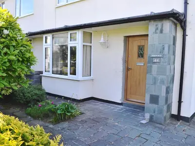a white house with a wooden door at Roseworth in Portinscale