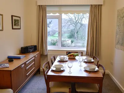 a dining room with a table and a window at Whitegates in Portinscale