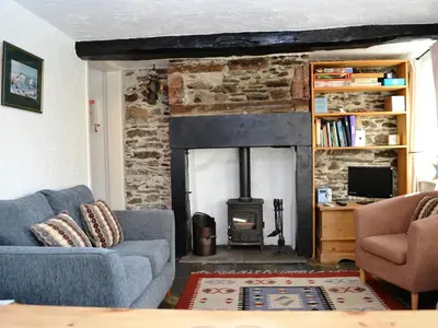a living room with a couch and a fireplace at Blease Cottage in Threlkeld