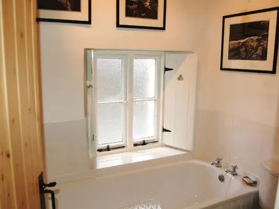 a bathroom with a bath tub and a window at Foxhole in Threlkeld
