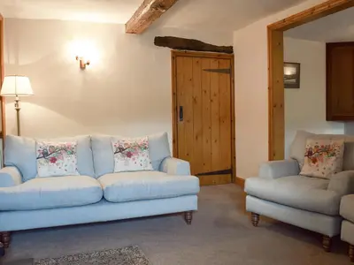 a living room with a couch and two chairs at Bridge House in Threlkeld