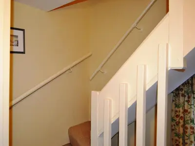 a staircase with white railings in a house at Brasscam in Rosthwaite