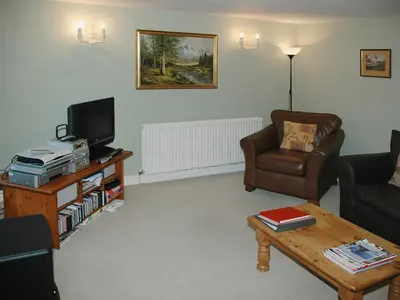 a living room with a couch and a tv and a table at Chapelfield Cottage in Rosthwaite