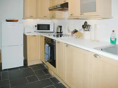 a kitchen with a white refrigerator and a sink at Chapelfield Cottage in Rosthwaite