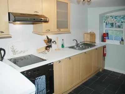 a kitchen with a sink and a stove at Chapelfield Cottage in Rosthwaite