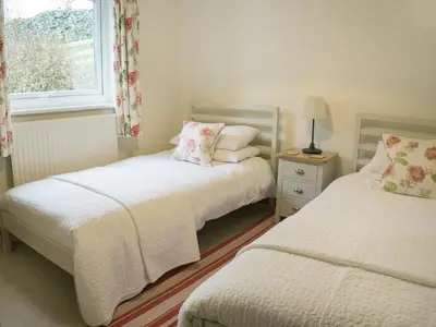 two beds in a small room with a window at Lookin How in Dockray