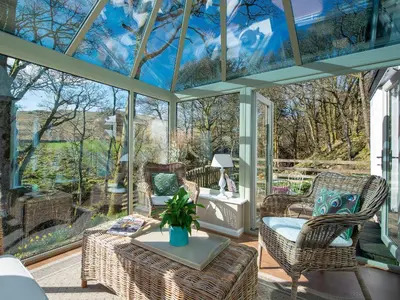 a conservatory with a glass ceiling with chairs and a table at Lookin How in Dockray