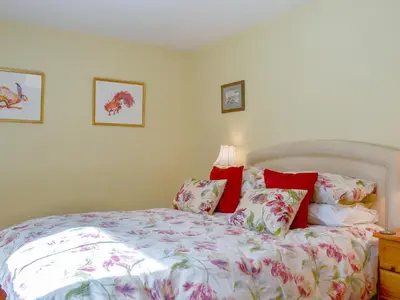 a bedroom with a large bed with red pillows at 3 Highrake in Glenridding