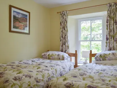 two twin beds in a room with a window at 3 Highrake in Glenridding