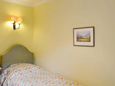 a bedroom with a bed and a picture on the wall at The Old Stables in Uldale