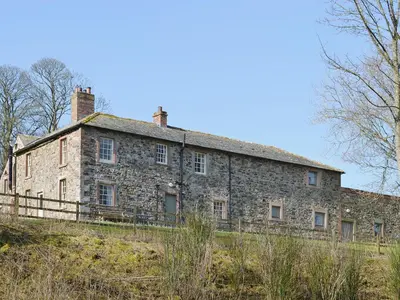 an old stone house on top of a hill at The Old Stables in Uldale