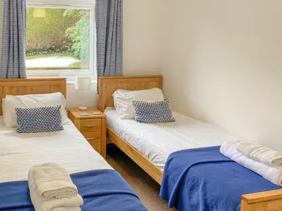 a bedroom with two beds and a window at Fourwinds in Keswick