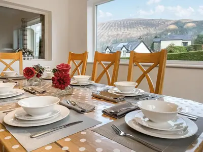 a dining room table with plates and bowls and utensils at Fourwinds in Keswick