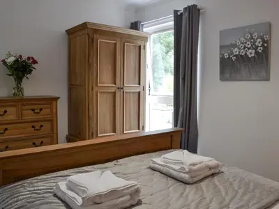 a bedroom with a bed and a dresser and a window at Fourwinds in Keswick