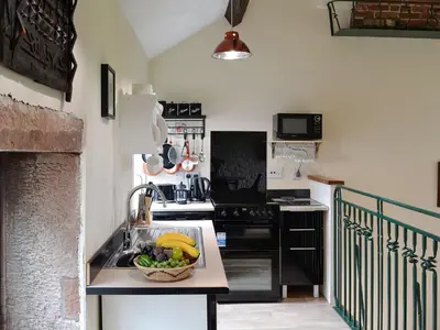 a kitchen with a sink with a bowl of fruit at Grooms Cottage in Plumbland