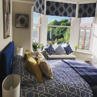 a bedroom with a bed with gold pillows on it at Lismore Guest House in Whitehaven