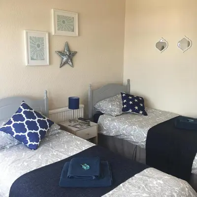 a bedroom with two beds and a starfish on the wall at Lismore Guest House in Whitehaven