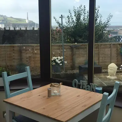 a wooden table and chairs in a room with a window at Lismore Guest House in Whitehaven