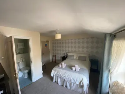 a bedroom with a bed with two pink pillows at The Queens in St Bees