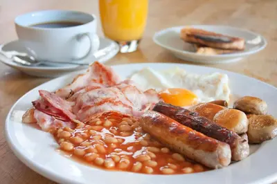 a plate of breakfast food with beans and eggs and a cup of coffee at The Sefton in Douglas