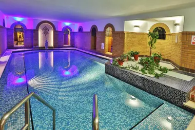 a swimming pool in a building with purple lighting at The Sefton in Douglas