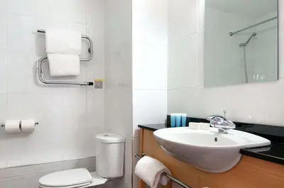 a white bathroom with a sink and a toilet at Best Western Palace Hotel & Casino in Douglas