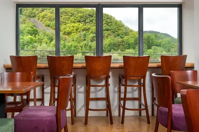 a room with a table and chairs and a large window at The Lodge In The Vale in Thirlmere