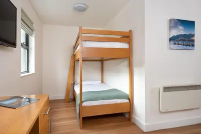 a bunk bed in a room with a desk at The Lodge In The Vale in Thirlmere