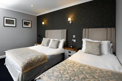 a hotel room with two beds in it at The Farmers Inn in Dumfries