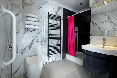a bathroom with a sink and a toilet and a shower at The Farmers Inn in Dumfries