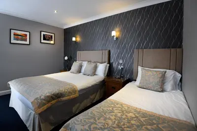 a hotel room with two beds in a room at The Farmers Inn in Dumfries