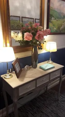 a table with two lamps and a vase with flowers on it at Blueberry Two Bedroom Suite for 1, 2 or 3 people in Douglas