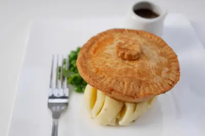 a bagel and bananas on a plate with a fork at Selkirk Arms Hotel in Kirkcudbright
