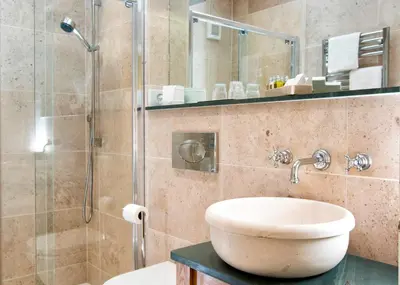 a bathroom with a sink and a glass shower at Hazel Bank Country House Borrowdale Valley in Rosthwaite
