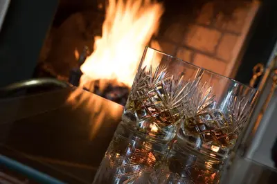 two glass vases sitting in front of a fireplace at Hazel Bank Country House Borrowdale Valley in Rosthwaite