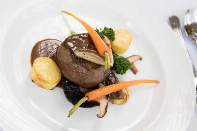 a plate of food with meat and vegetables on it at Hazel Bank Country House Borrowdale Valley in Rosthwaite