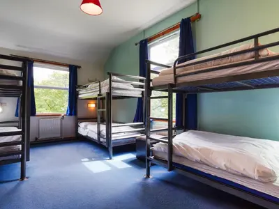 a room with three bunk beds in a house at YHA Borrowdale in Rosthwaite